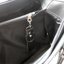 Load image into Gallery viewer, Black pen holder keyfob clipped to the internal zip of a black handbag
