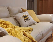 Load image into Gallery viewer, Bumblebee cushion on a sofa with a yellow throw