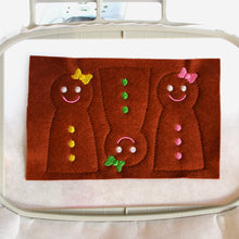 Load image into Gallery viewer, The finished embroidery of three gingerbread girl candy cane holders ready for cutting out