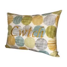 Load image into Gallery viewer, Cwtch cushion on light blue and yellow circles viewed from the right side