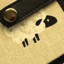 Load image into Gallery viewer, Close of of sheep fabric notebook with black tab and metal fastener