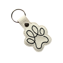 Load image into Gallery viewer, Paw print keyring in white faux leather with black stitching with metal rivet and split ring