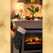 Load image into Gallery viewer, Snowflake Christmas stocking in green hanging from a mantlepiece