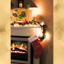 Load image into Gallery viewer, Snowflake Christmas stocking in red hanging from a mantlepiece
