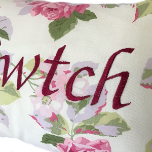 Cwtch cushion in Laura Ashley pink floral fabric close up of stitched wording