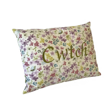 Load image into Gallery viewer, Cwtch cushion stitched in green on floral fabric viewed from the left side
