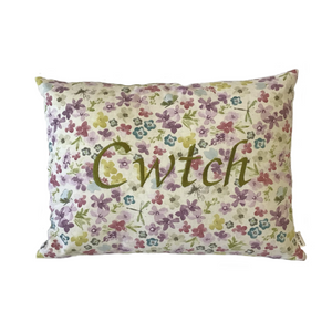 Cwtch cushion stitched in green on floral fabric