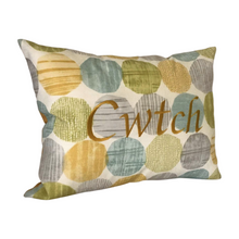 Load image into Gallery viewer, Cwtch cushion on light blue and yellow circles viewed from the left side
