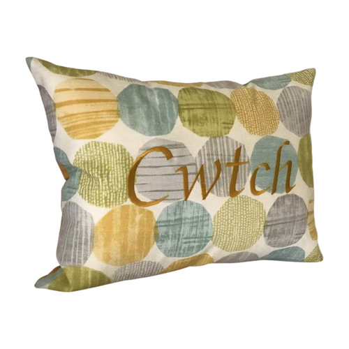Cwtch cushion on light blue and yellow circles viewed from the left side