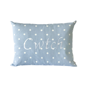 Cwtch cushion on powder blue polka dot fabric