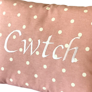 Cwtch cushion with white stitching on pink polka dot fabric