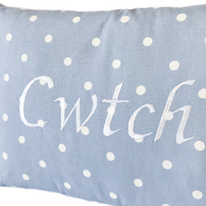 Cwtch cushion with white stitching on powder blue polka dot fabric