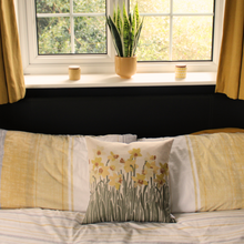 Load image into Gallery viewer, Daffodil cushion on a bed
