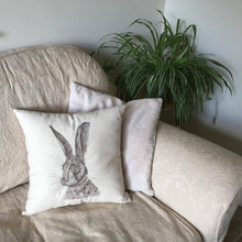 Load image into Gallery viewer, Embroidered hare cushion on a sofa
