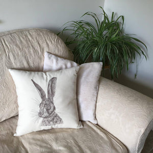 Embroidered hare cushion on a sofa