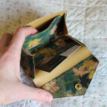 Load image into Gallery viewer, A gold leaf cork purse opened to show the mustard coloured faux leather lining with a receipt pocket and central area for coins
