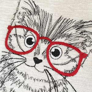 Kitten with red glasses close up of face