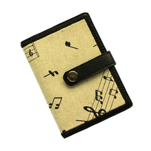 Load image into Gallery viewer, Notebook with musical notes fabric on a beige background stitched on to black faux leather with tab closure and metal rivet fastener
