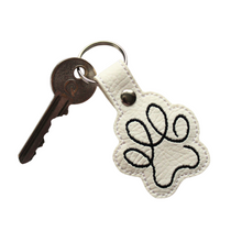 Load image into Gallery viewer, Paw print keyfob in white faux leather with black stitching and key attached

