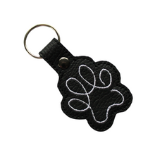 Load image into Gallery viewer, Paw print keyring in black faux leather with white stitching and metal rivet and split ring
