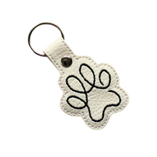 Load image into Gallery viewer, Paw print keyring in white faux leather with black stitching with metal rivet and split ring
