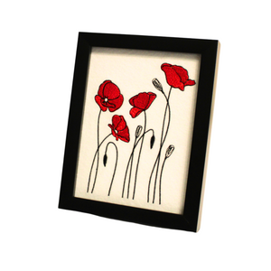 Poppies embroidered art in a black frame