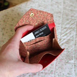 A red vine cork purse opened to show the credit card inserts, receipt pocket and central area for coins