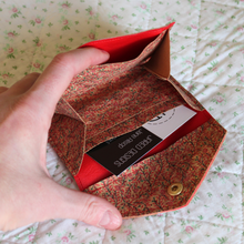 Load image into Gallery viewer, A red vine cork purse opened to show the red faux leather lining with a receipt pocket and central area for coins
