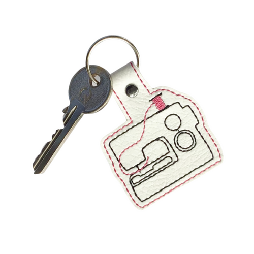 Sewing machine keyfob with pink thread and key attached