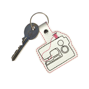 Sewing machine keyfob with pink thread and key