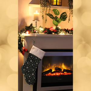 Snowflake Christmas stocking in green hanging from a mantlepiece