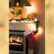 Load image into Gallery viewer, Snowflake Christmas stocking in red hanging from a mantlepiece
