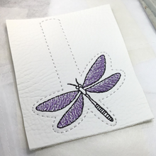 Load image into Gallery viewer, Dragonfly keyfob completed stitching in purple and black threads on to white faux leather
