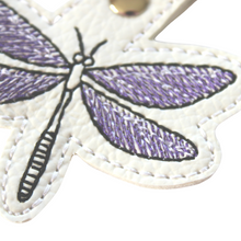 Load image into Gallery viewer, Dragonfly keyfob close up of lower wing stitched in purple and black thread on to white faux leather
