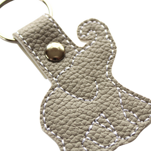 Elephant keyfob on grey faux leather close up of stitching