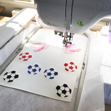Load image into Gallery viewer, Football keyfobs being stitched
