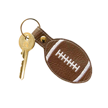Load image into Gallery viewer, Rugby ball keyfob with white stitching on brown faux leather with metal rivet and split ring and key attached
